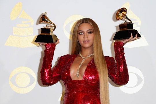 Beyoncé holding up two Grammys  