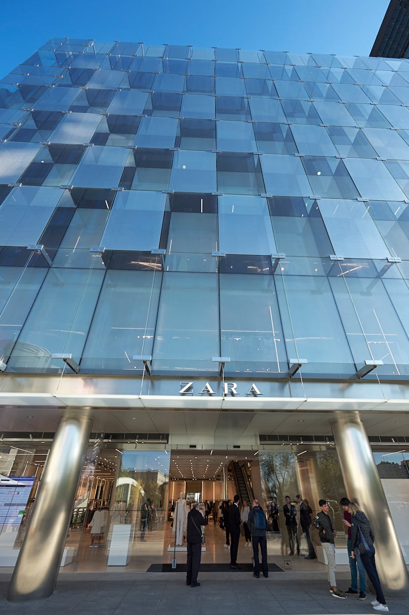 Zara store located in a big glass building with people in front of the entrance.