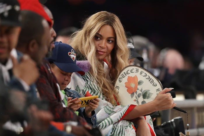 Beyoncé with her blonde hair down, looking towards the people sitting next to her at an event 