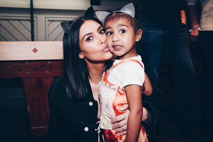 Kim Kardashian posing for a photo with her daughter North West