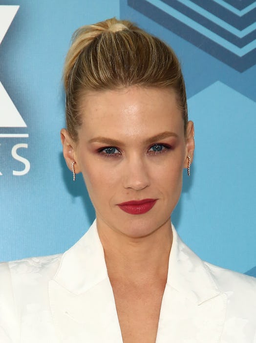 January Jones with a braided updo wearing a white suit 