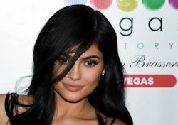 Kylie Jenner with her hair down, slightly covering her face posing at a red carpet