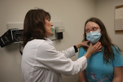 Doctor checking woman for flu symptoms