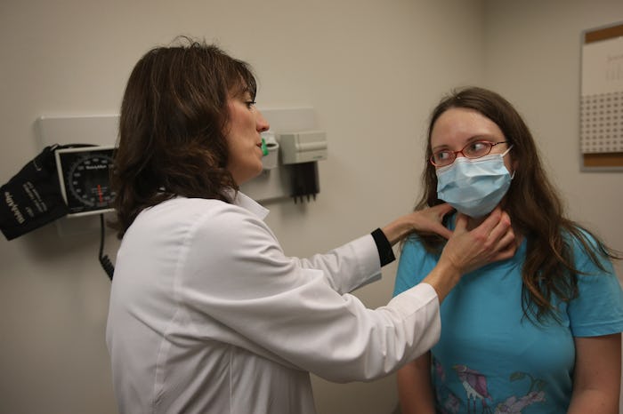 Doctor checking woman for flu symptoms