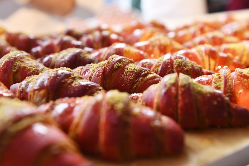 Table full of pink pistachio croissants. 