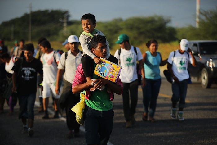 A group of Migrant Caravan Families & Children walking down the street