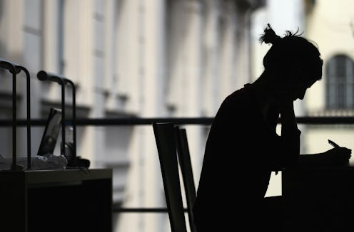 A silhouette of a woman with a dissociative identity disorder sitting alone in the dark