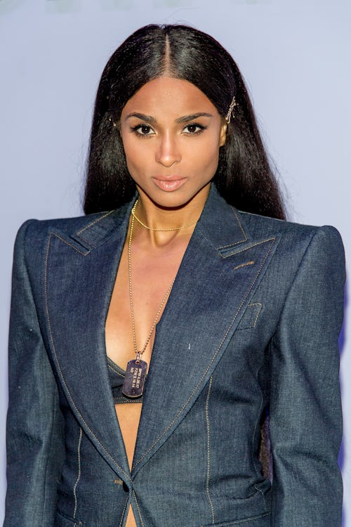 Ciara in an opened dark blue blazer with a lace bralette underneath 