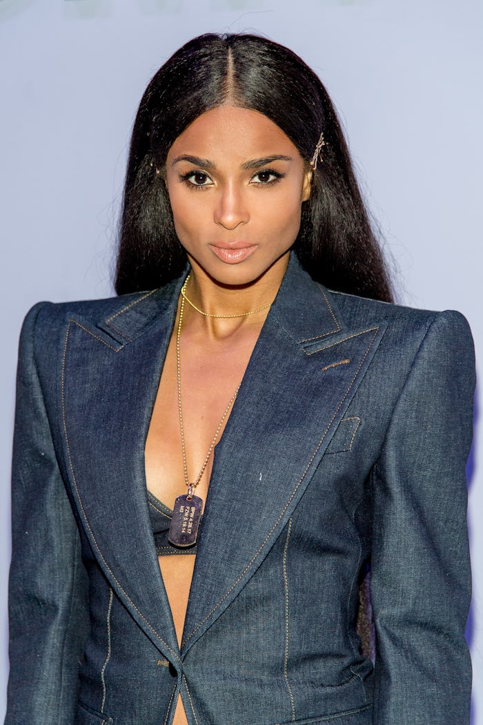 Ciara in an opened dark blue blazer with a lace bralette underneath