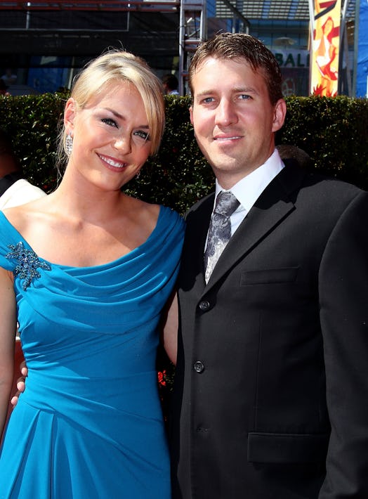 Lindsey Vonn wearing a blue dress posing for the picture with her ex-husband wearing a suit