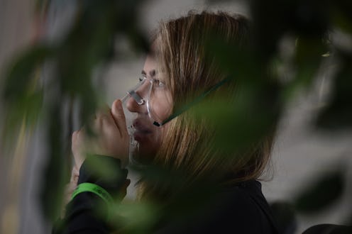 A woman with lyme disease holding a breathing mask over her face
