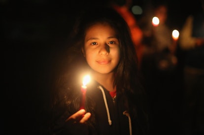 A girl holding a lit candle