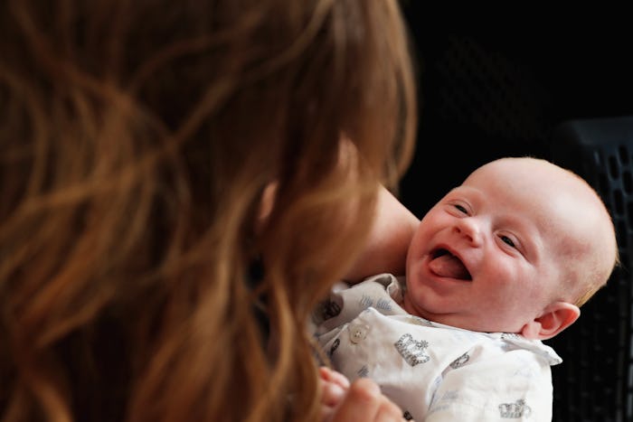 A mother holding her smiling newborn baby. 