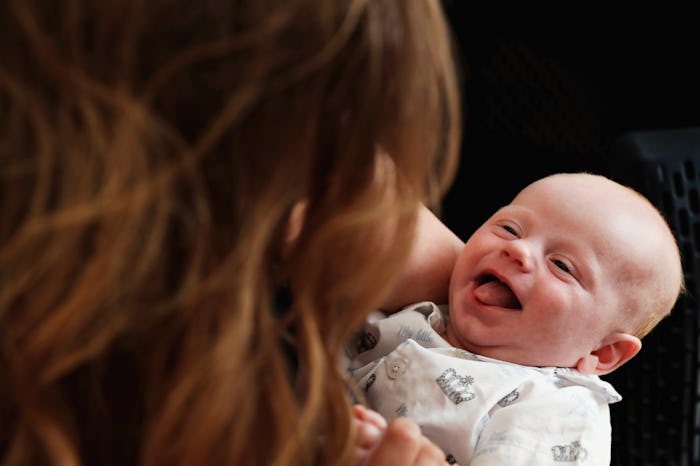 A mother holding her smiling newborn baby.