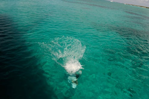 A person snorkeling in a crystal-clear emerald-green water