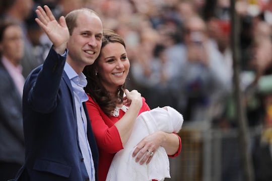 Kate walking with William while carrying her newborn baby