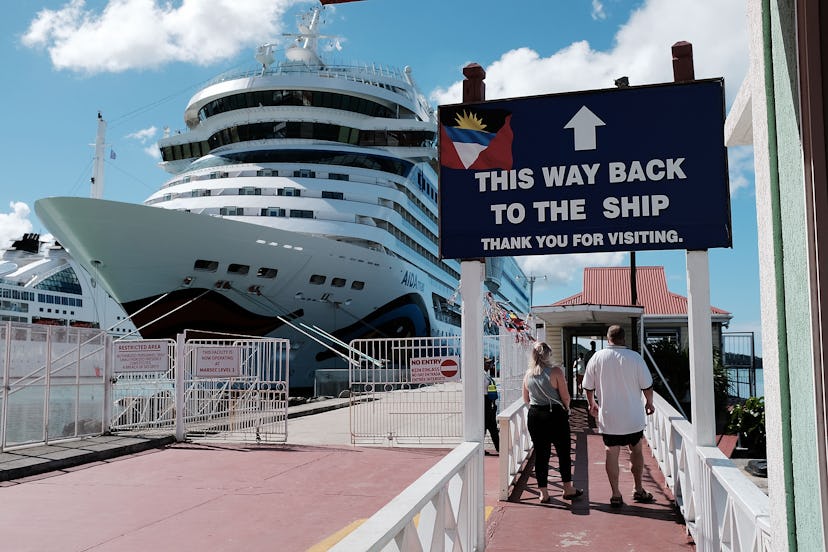 A cruise ship on the harbor with a sign at the beginning that indicates the direction which way to t...