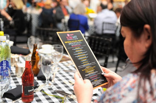 A woman in a restaurant looking at the calorie counts on the menu