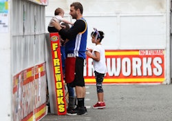 A dad and two children in front of a Fireworks store in New Jersey
