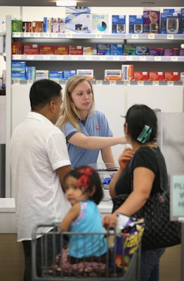 A mom and dad in a pharmacy getting meds for their child's ear infection