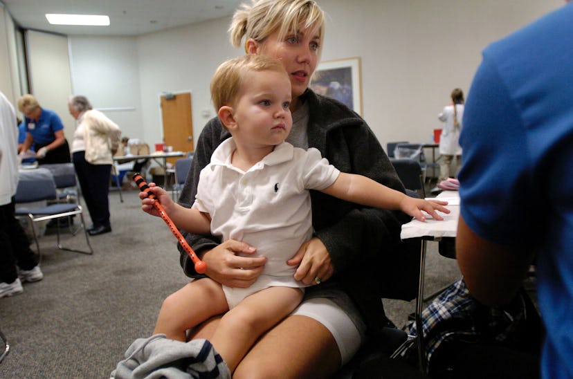 A kid sitting in his mom's lap before getting checked for an ear infection