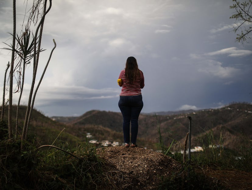 a Midwife after Hurricane Maria standing on top of hill looking down on the landscape
