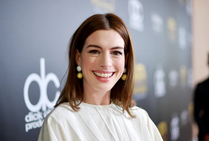 Anne Hathaway smiles during a red carpet appearance.
