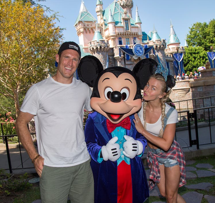 Julianne Hough and Brooks Laich posing for a picture in front of the castle with Mickey Mouse is a f...