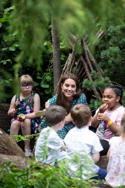 Kate Middleton sits with children at a royal event. 