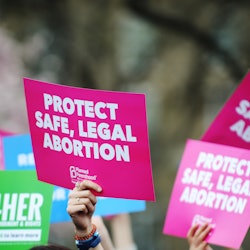 A pro-abortion protester holds up a sign saying "protect safe, legal abortion." A new California law...
