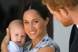 Meghan Markle holding Archie, looking at the camera, as Prince Harry is looking at the two of them