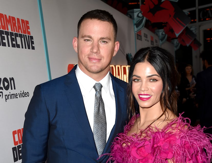 Channing Tatum in a navy suit and white shirt and Jenna Dewan in a pink dress at a red carpet event
