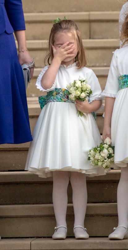 Princess Charlotte was photographed at Princess Eugenie's wedding with her hand over her face. 
