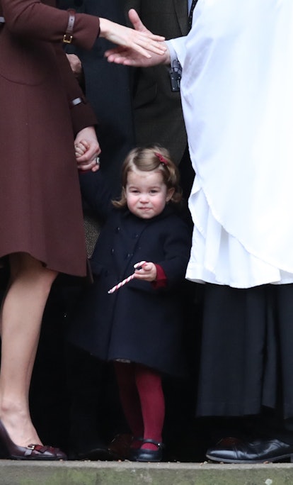 Princess Charlotte stares at photographers while her mom chats above her. 