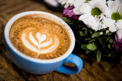 A latte in a blue mug. Bloating remedies can be as simple as swapping out milk for a non-dairy alter...