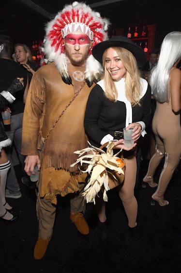 Hilary Duff and Jason Walsh wearing costumes of Native American clothing and a pilgrim outfit. Avoid...