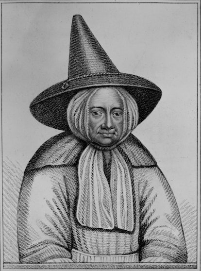 A drawing of a witch wearing a scarf beneath her black pointed hat and a wide dress.
