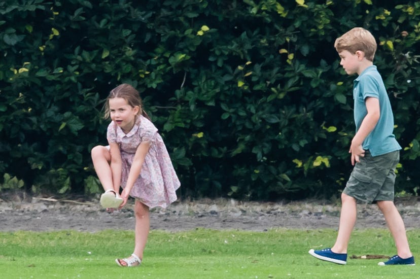 The royal kids are dressed up while playing outside.