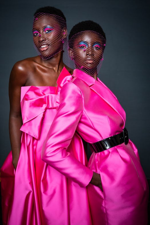 Two black women posing in pink silk outfits