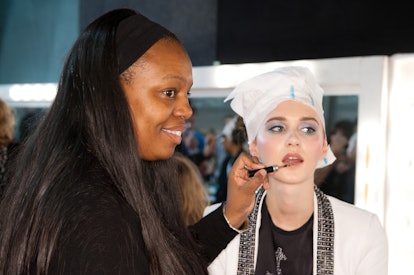 Make-up artist Pat McGrath putting lipstick on lips of a girl