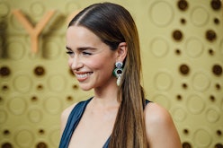 Emilia Clarke with her hair down and dangly earrings at an event 