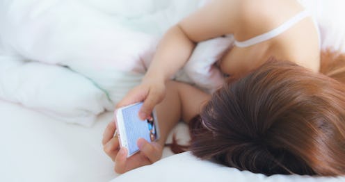 A woman checks her phone first thing in the morning