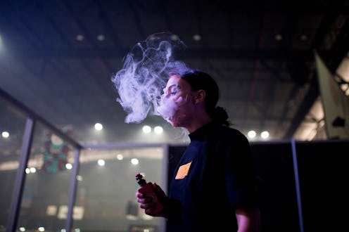 A woman vapes. Health effects of vaping for women at present are unknown.