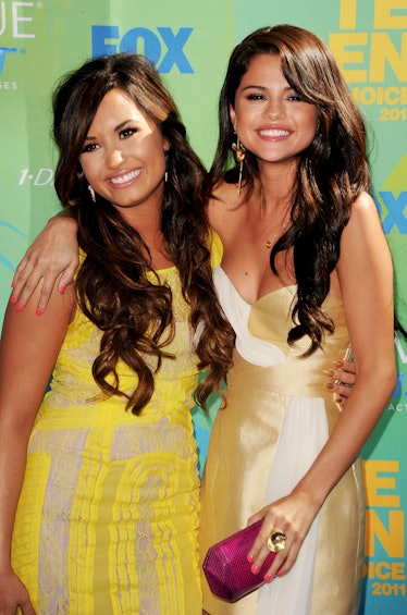 Selena Gomez and Demi Lovato flash wide smiles at the 2011 Teen Choice Awards.