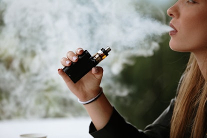 A woman vapes. Vaping could have impacts on women's reproductive health, as researchers are uncoveri...