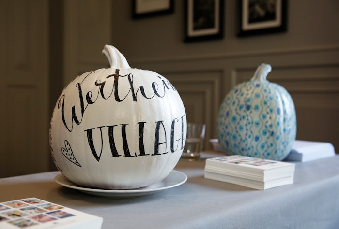 Two DIY stenciled pumpkins on a table