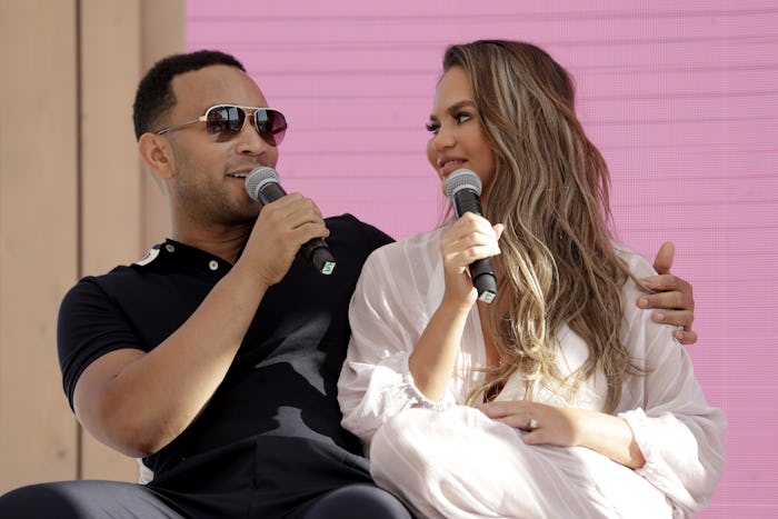 Chrissy Teigen and John Legend with microphones during an interview