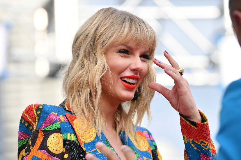 Taylor Swift poses in a colorful patterned jacket. She is a strong advocate of female empowerment.