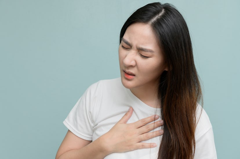 A woman experiences heartburn. Lower amounts of coffee daily may reduce symptoms of heartburn and ac...