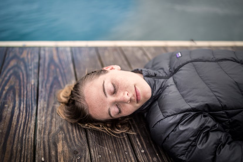 A woman sleeps on a pier. Reducing coffee consumption may help sleep patterns and improve restful sl...